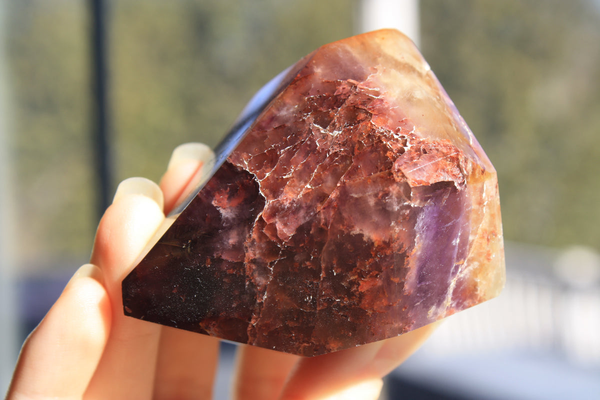 Red Dreamcoat Lemurian seed quartz tower with Super 7 inclusions and a Lemurian quartz core close up