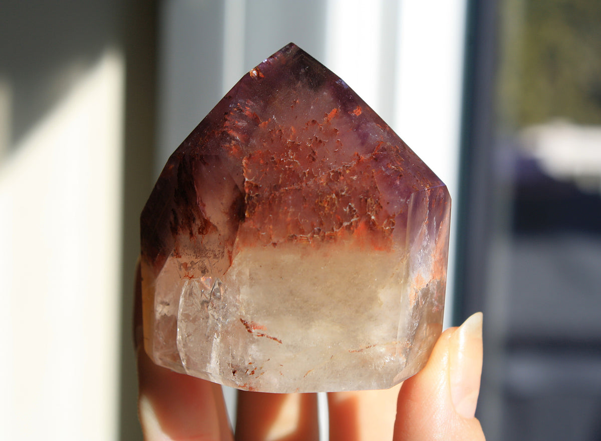 Red Dreamcoat Lemurian seed quartz tower with Super 7 inclusions and a Lemurian quartz core.