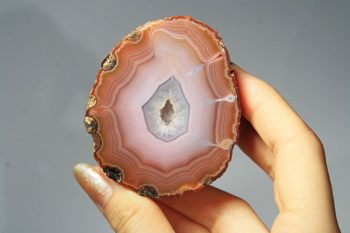 Large pink Zhanguo agate featuring natural banded patterns and a smooth polished finish