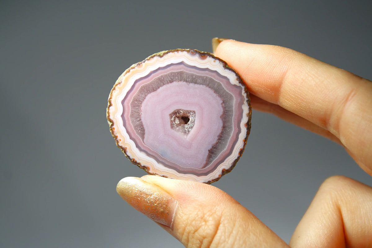 Polished purple and pink Zhanguo agate displaying vibrant color layers and organic patterns