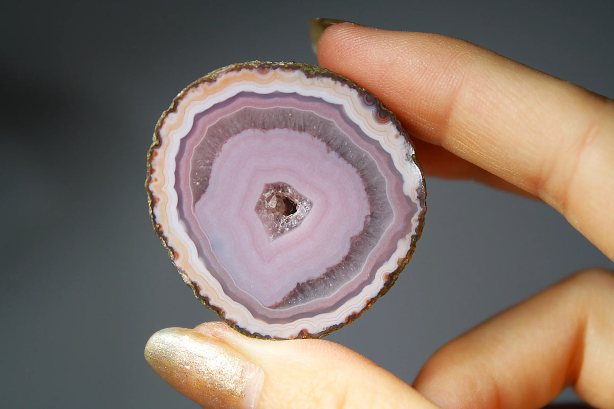Polished purple and pink Zhanguo agate displaying vibrant color layers and organic patterns