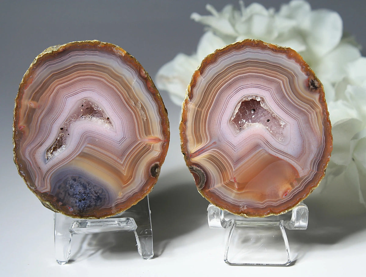 Vibrant Zhanguo agate pair with blue bands swirling among crimson, gold, and jade tones