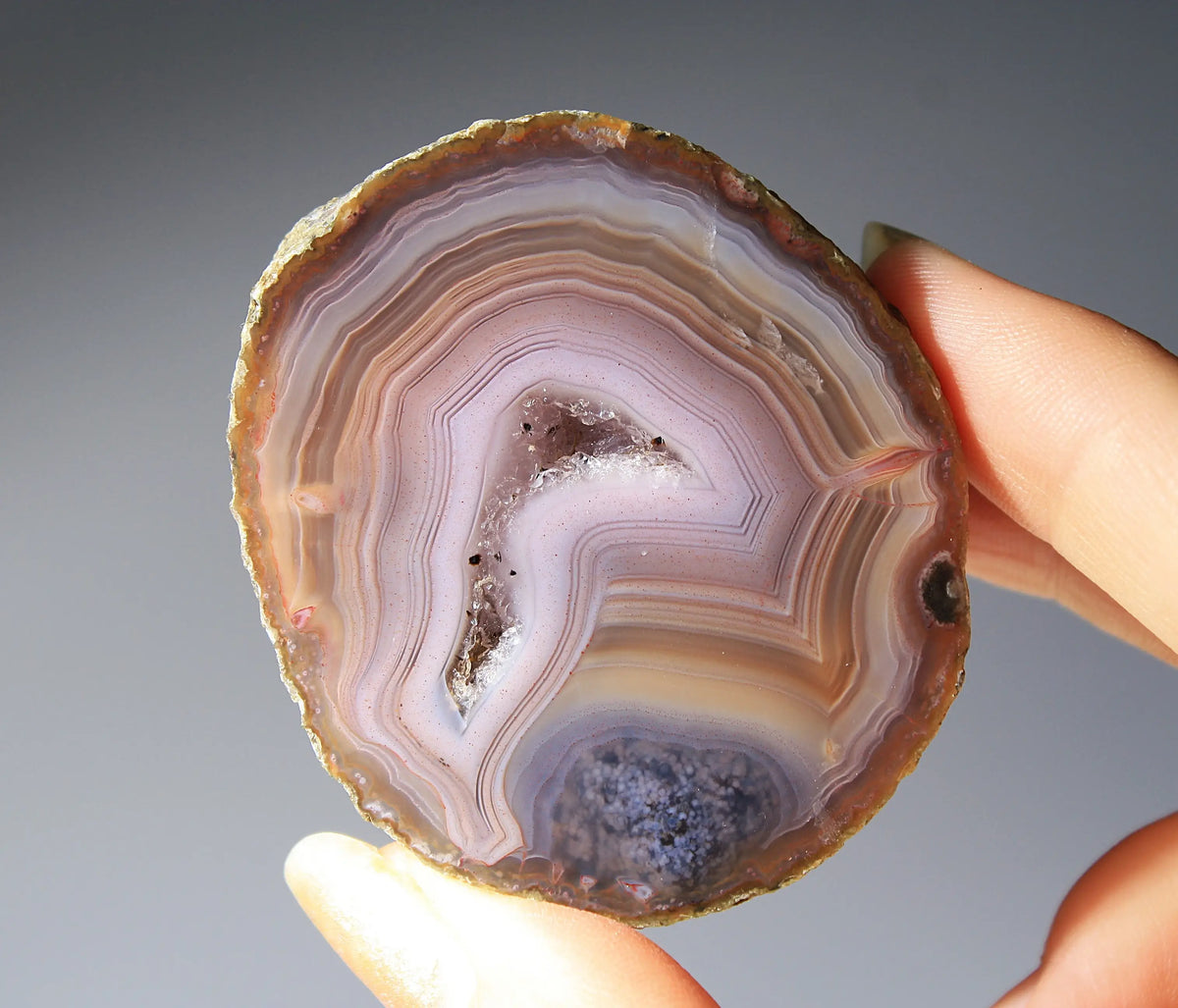 Vibrant Zhanguo agate pair with blue bands swirling among crimson, gold, and jade tones