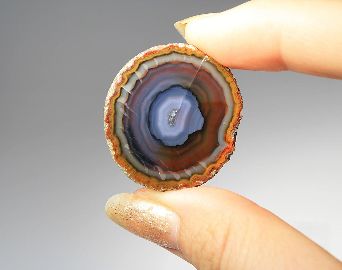 Banded purple-blue and orange Zhanguo agate pair with vivid swirling layers
