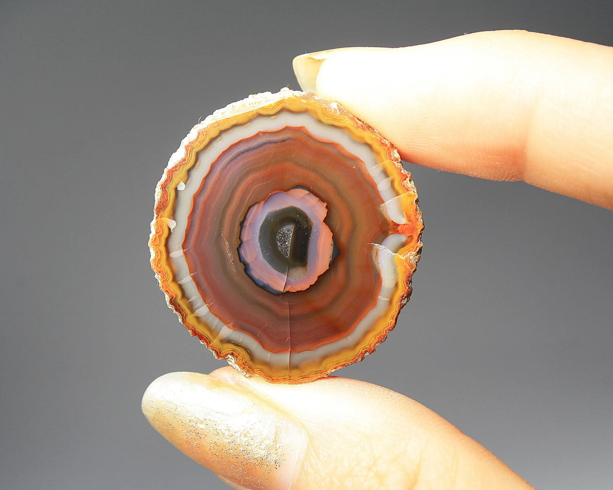 Banded purple-blue and orange Zhanguo agate pair with vivid swirling layers