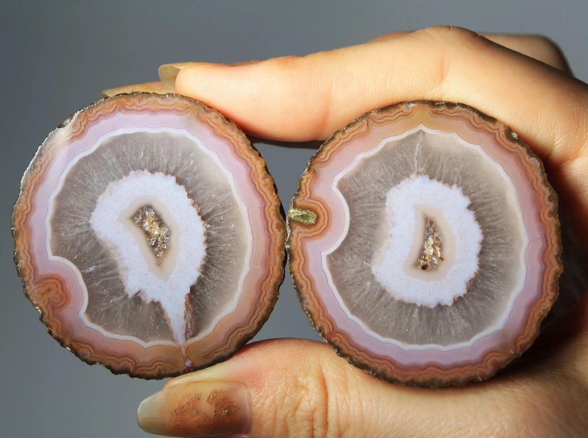 Vibrant pink-orange agate pair with flowing, luminous bands