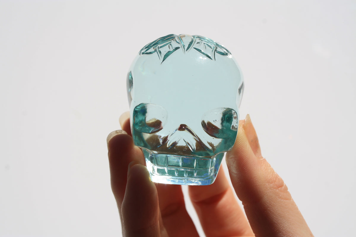 Blue obsidian crystal skull with hand‑engraved butterfly designs by artisan Vikas Meena.