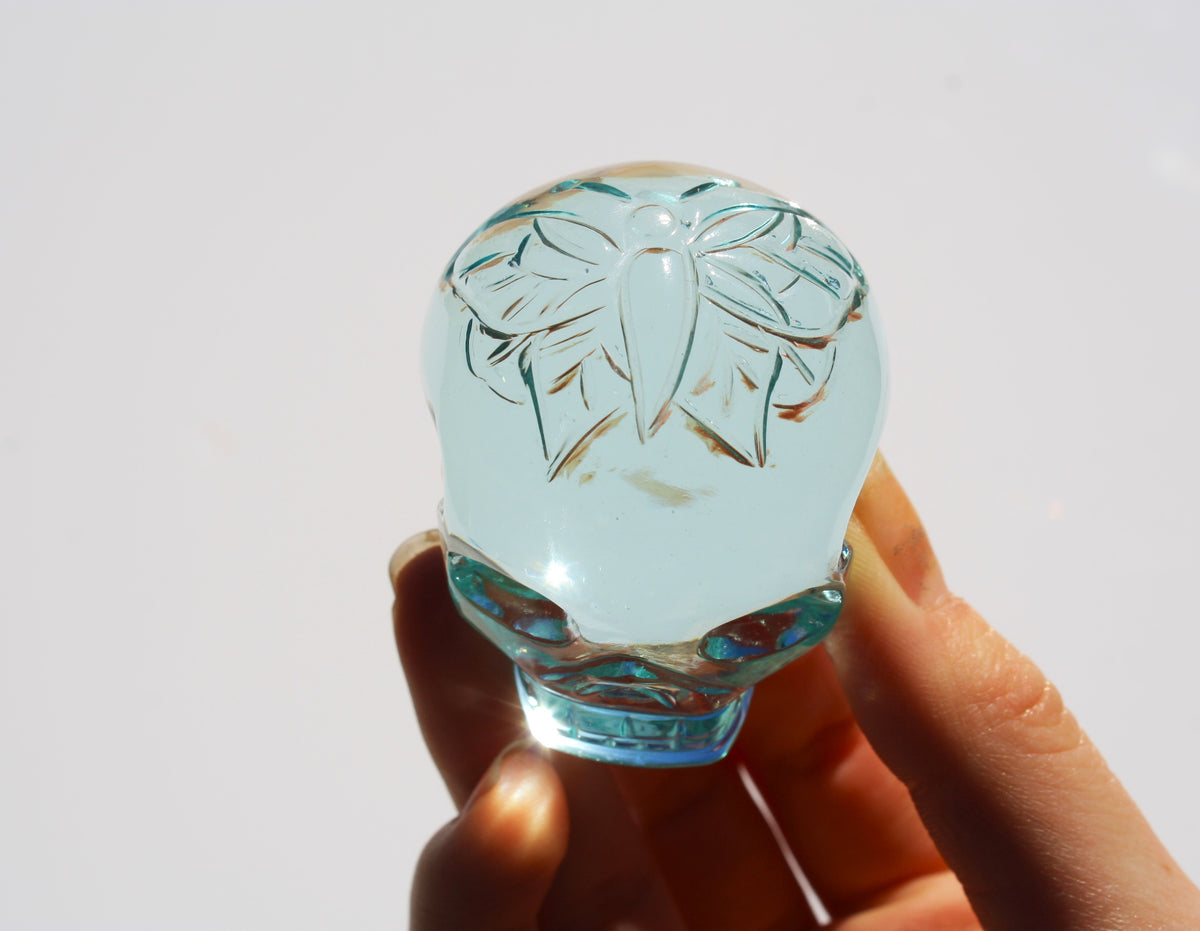Blue obsidian crystal skull with hand‑engraved butterfly designs by artisan Vikas Meena.
