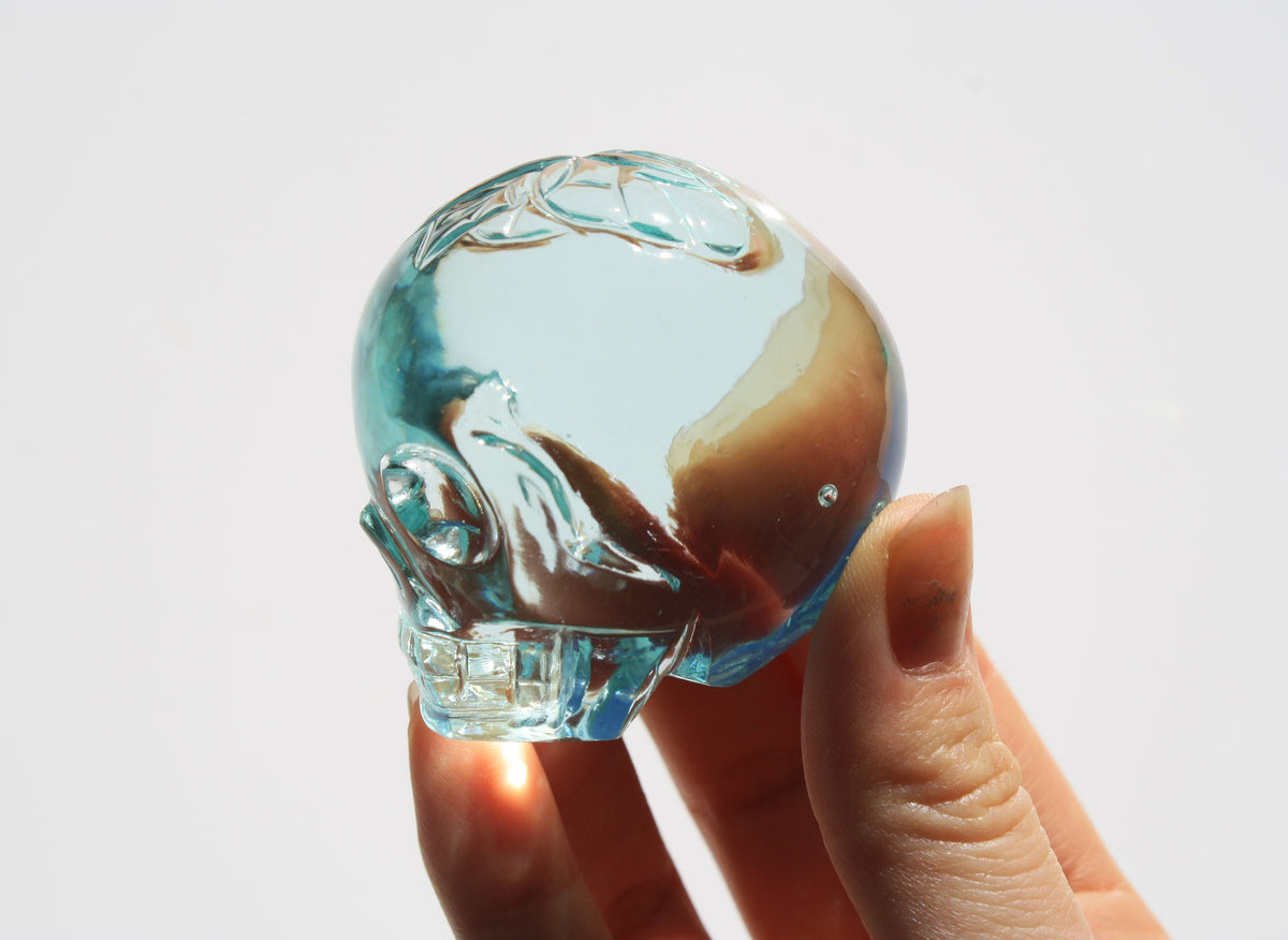 Blue obsidian crystal skull with hand‑engraved butterfly designs by artisan Vikas Meena side view