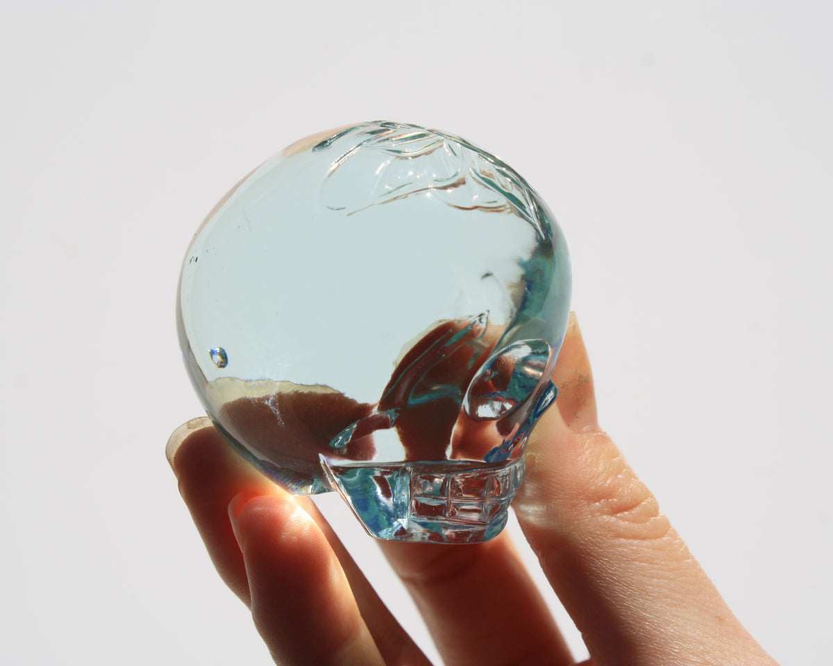 Blue obsidian crystal skull with hand‑engraved butterfly designs by artisan Vikas Meena side view